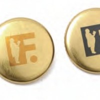 フランクのロゴ「F」を配したゴールド缶バッジ