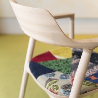 ミナ ペルホネンのオリジナルテキスタイルの祭壇した際にでるはぎれなどの余り布をパッチワークとしてつなぎ合わせた座面のファブリック。椅子の材質（ビーチ／オーク／ウィルナット）の色合いに沿った3タイプのデザインが考案された。