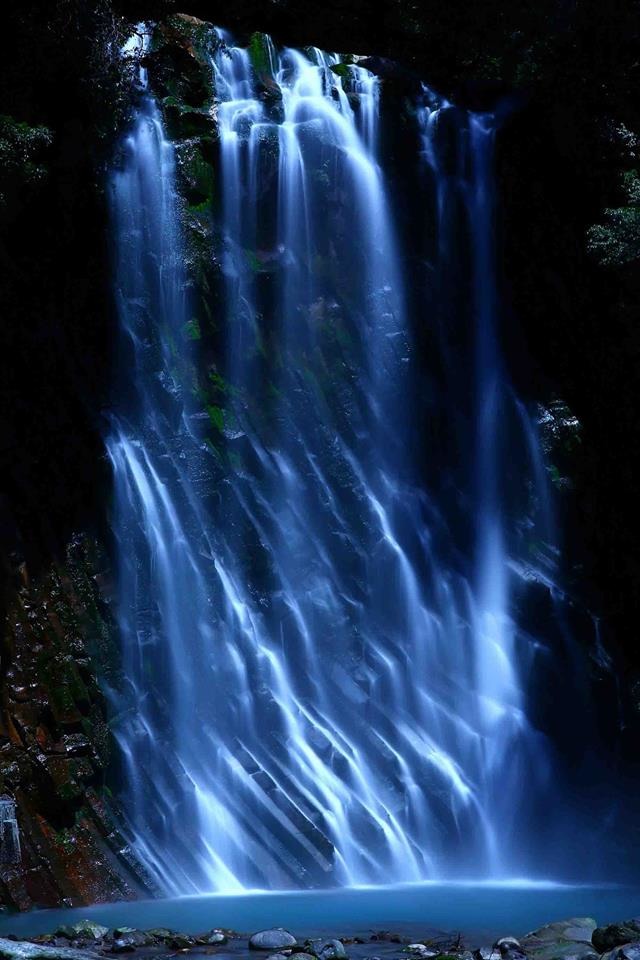「月夜の滝」。鹿児島県霧島の「丸尾の滝」。飛沫が凍りつくほどの寒い1月の夜、満月に照らされて輝きながら、柱状節理の模様の岩肌を流れる