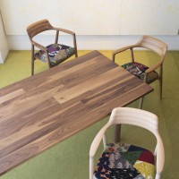 深澤直人がデザインした椅子「HIROSHIMA」（手前からビーチ。オーク、ウォルナット）に皆川明デザインのファブリックを座面に施したペシャルチェアと、端材をパッチワークして作った無垢天板のテーブル「MALNI」。