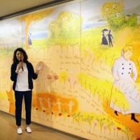 高松赤十字病院の西玄関に描いた作品の原画の前で話す山本氏