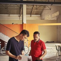 Artist Sean Lean (MY) and KENZO's Humberto Leon reviewing notes and sketches in Cambodia