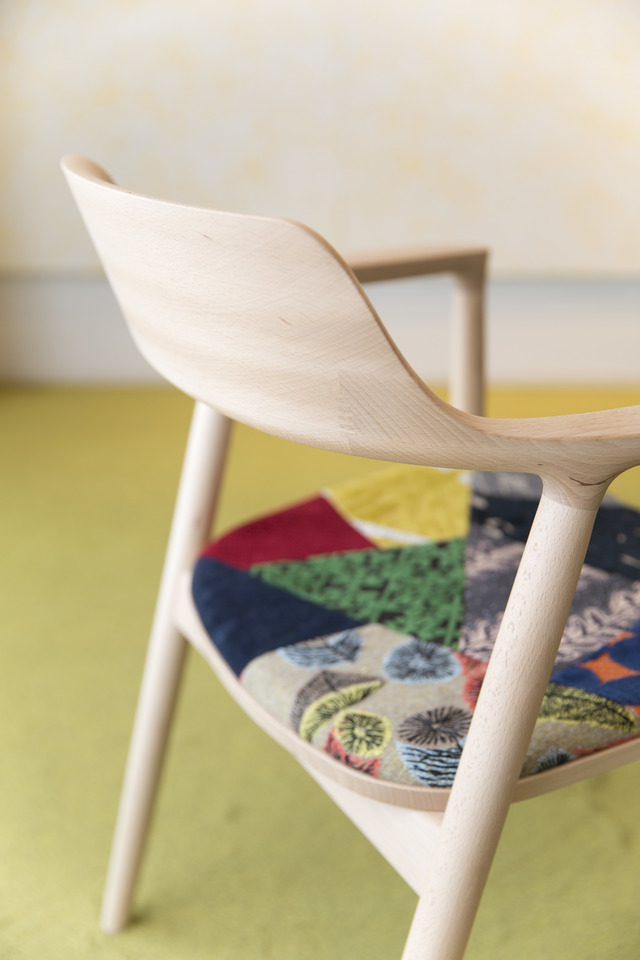 ミナ ペルホネンのオリジナルテキスタイルの祭壇した際にでるはぎれなどの余り布をパッチワークとしてつなぎ合わせた座面のファブリック。椅子の材質（ビーチ／オーク／ウィルナット）の色合いに沿った3タイプのデザインが考案された。