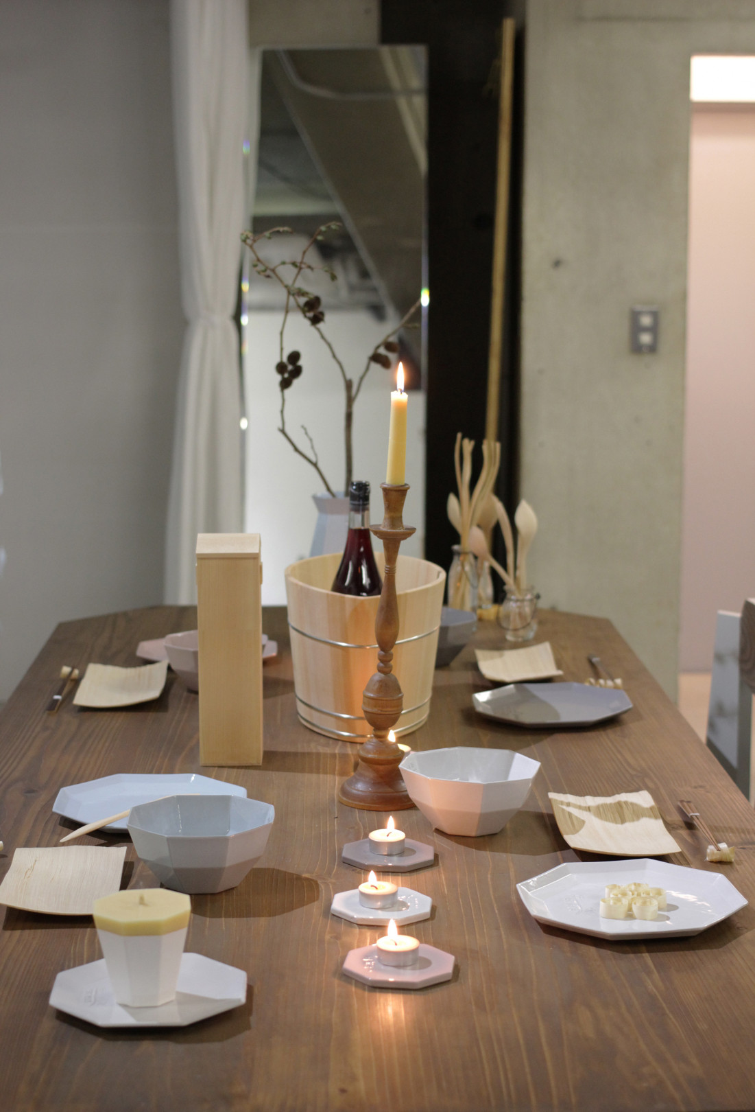 KIKOFのテーブルに器、中川木工芸のカトラリーや取り皿が並ぶ。キャンドルスタンドには、柔らかな色合いの大與の和ろうそく。穏やかな温もりを感じさせる食卓演出